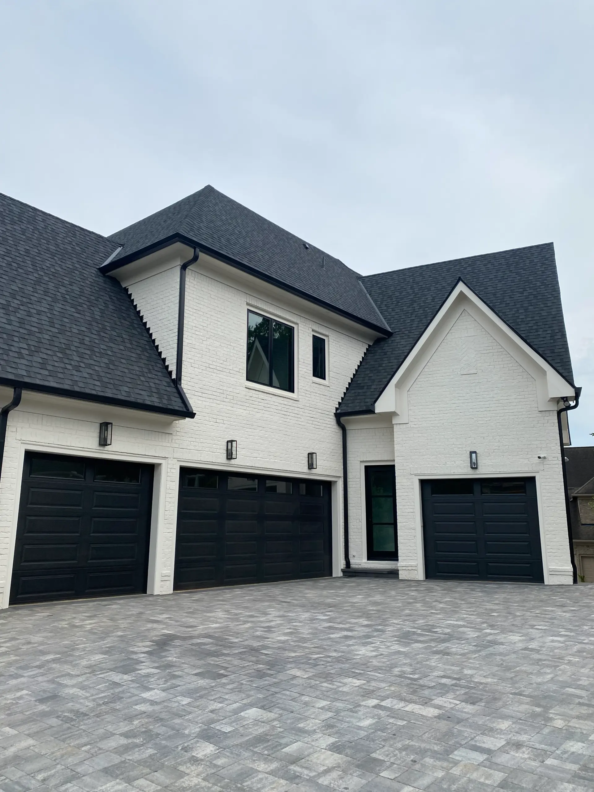 Luxury new construction home with triple black garage doors and paver driveway in Gwinnett County Georgia