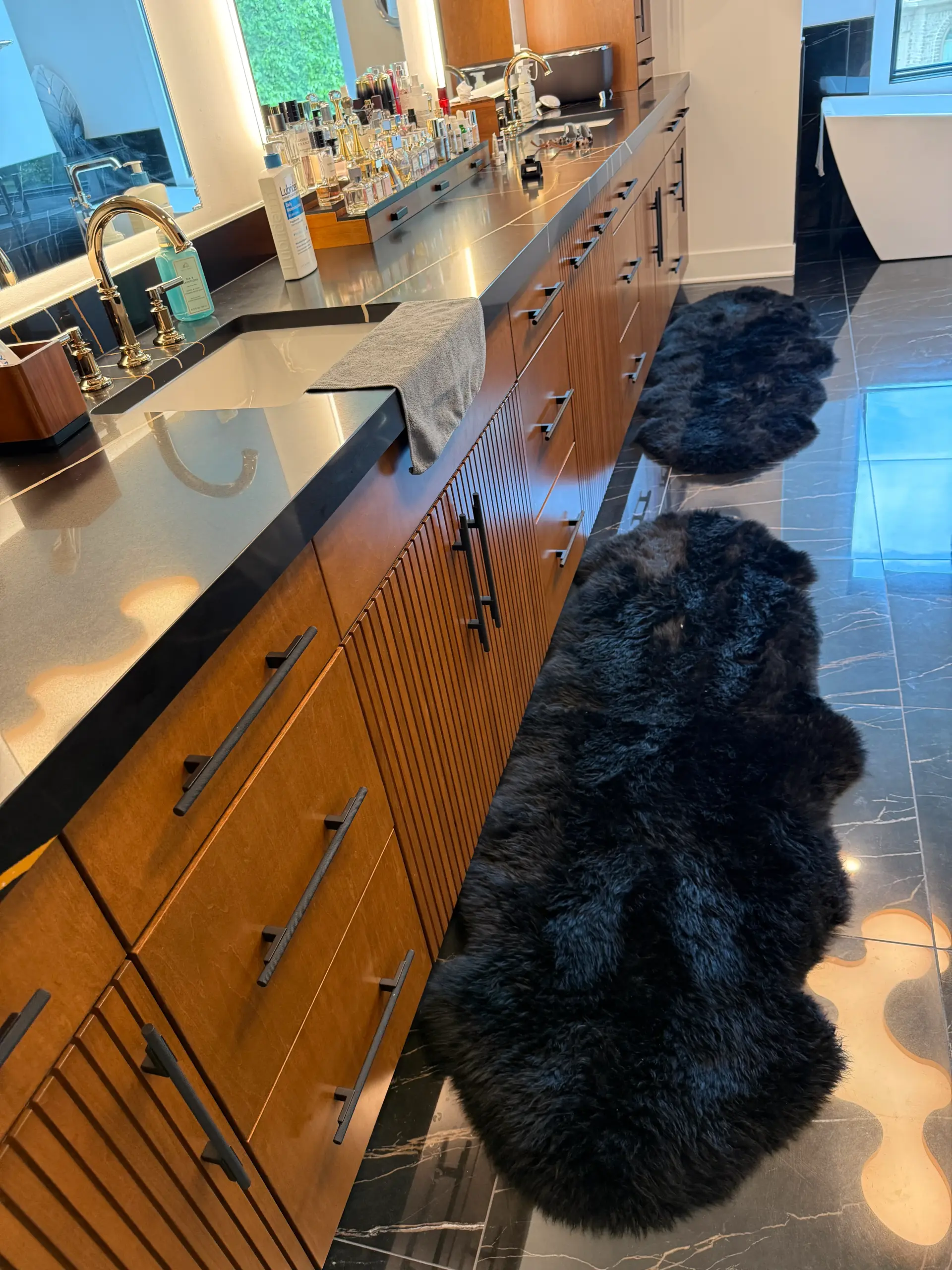 Long linear bar counter with black marble and fluted wood cabinetry in luxury home entertainment room