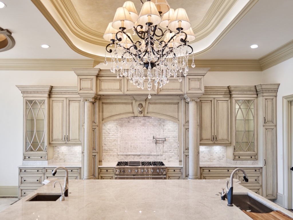 Custom luxury kitchen with crystal chandeliers and raised-panel cabinetry
